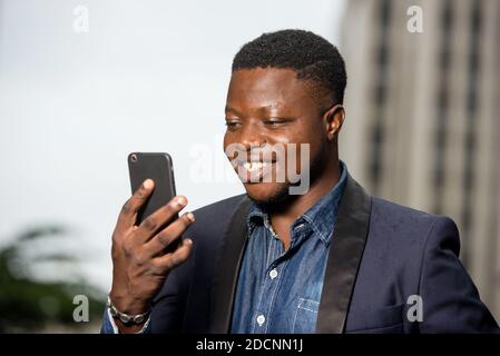 Happy young business man happy and checking cell phone messages. Man concept enjoys success in work. Stock Photo
