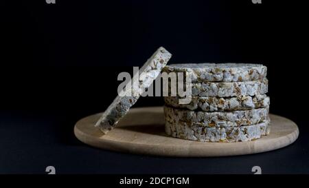 Grain crispbreads crispy rice and diet bread. Stack of puffed whole grain crispbread. Rice cake puffed rice on black background Stock Photo