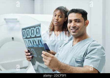 Happy mixed-race radiologist and his African female assistant looking at you Stock Photo