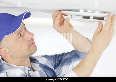 senior male reaching up to open filter holder Stock Photo