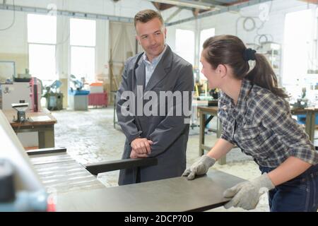 man working with apprentice in printing house Stock Photo