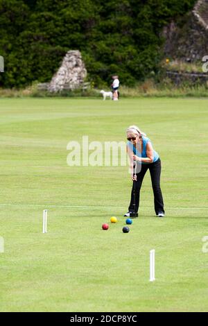 Bamburgh, Northumberland, England - July 16th 2020:Mature lady playing croquet in a rural setting in Northumbria, England Stock Photo