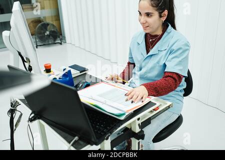 young man worked on computer and with paper, pencil in hands painted Stock Photo