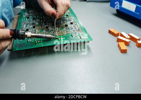 person welding with a soldering iron on a motherboard Stock Photo