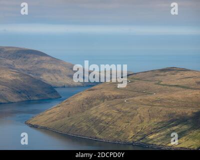 Picturesque remote view of roadway running in highland area near sea at daytime Stock Photo
