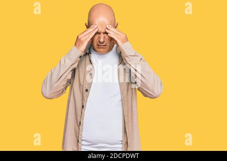 Middle age bald man wearing casual clothes with hand on head for pain in head because stress. suffering migraine. Stock Photo