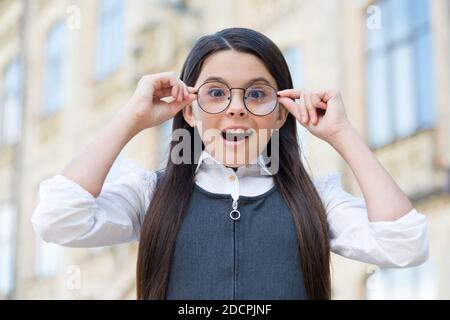 For smart look. Happy child put on glasses. Back to school look. Vision examination. Eye sight test. Optician salon. Pediatric ophthalmology. School education. See great without compromising style. Stock Photo