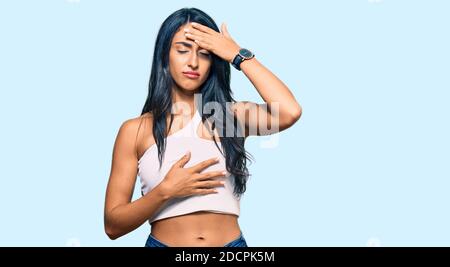 Beautiful hispanic woman wearing casual clothes touching forehead for illness and fever, flu and cold, virus sick Stock Photo