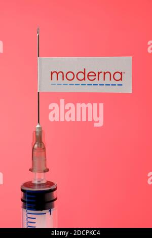 Stafford / United Kingdom - November 22 2020: Moderna vaccine Covid-19 concept. Syringe needle and sticker on it, blurred background. Real photo, not Stock Photo