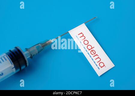 Stafford / United Kingdom - November 22 2020: Moderna vaccine Covid-19 concept. Syringe needle and sticker on it, blurred background. Real photo, not Stock Photo