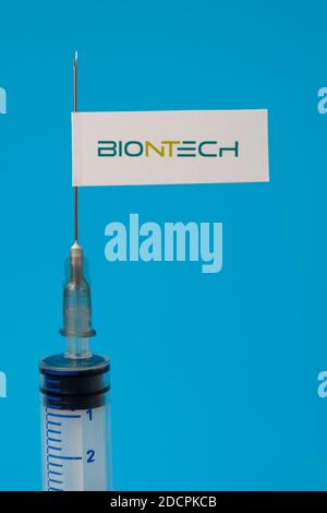 Stafford / United Kingdom - November 22 2020: BionTech vaccine Covid-19 concept. Syringe needle and sticker on it, blurred background. Real photo, not Stock Photo