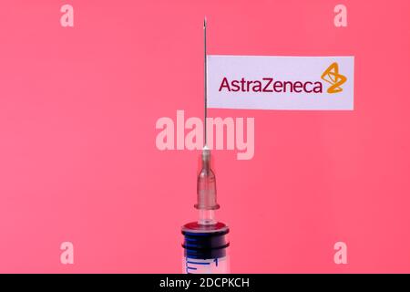 Stafford / United Kingdom - November 22 2020: AstraZeneca Oxford vaccine Covid-19 concept. Syringe needle and sticker on it, blurred background. Real