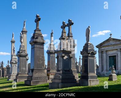 Queens, NY - November 16 2020: These tall funeral monuments are in the old section of Cavalry Cemetery, established in 1848. Calvary Cemetery has the Stock Photo