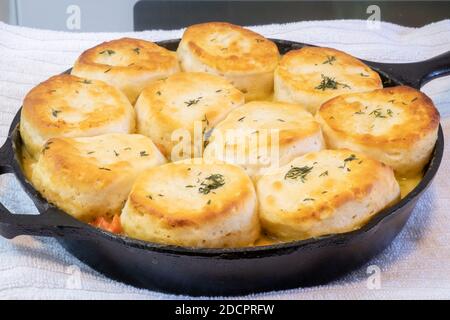 Chicken pot pie with biscuits used on top cooked to a toasty golden brown in a cast iron skillet. Stock Photo