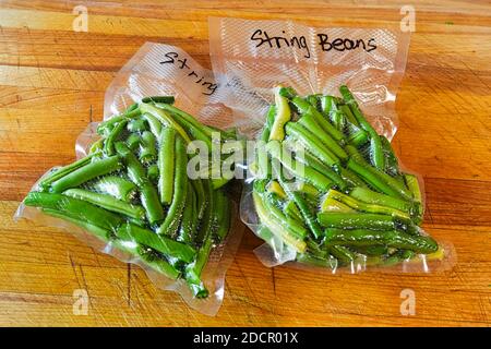 Two packages of fresh green beans vacuum sealed into bags Stock Photo