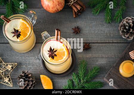 Hot rum, whiskey or brandy apple toddy cocktail drinks on rustic wooden table. Seasonal winter or Christmas hot spicy drink, mulled cider. Stock Photo