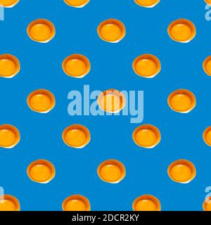 Seamless pattern of raw yellow eggs yolks on a blue background. Broken egg repeating ornament backdrop, Easter banner. Stock Photo