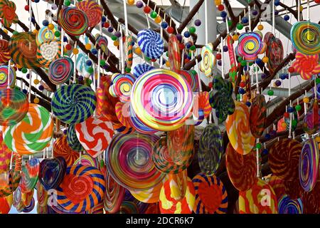A collection of colourful candies, candy canes and lollipops suspended from a tree. Stock Photo