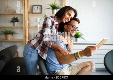 Couple in love hugging and using tablet together. Stock Photo