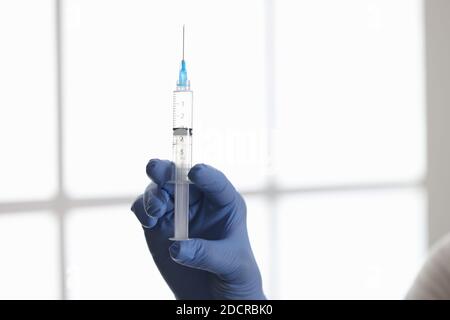 Doctors hand in rubber glove holding syringe with medicine in clinic closeup Stock Photo