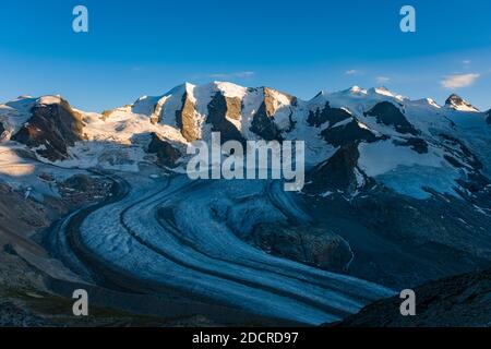 The summits of Piz Palü and Bella Vista and the Pers Glacier, seen from the cable car station and mountain hut Diavolezza at sunset. Stock Photo