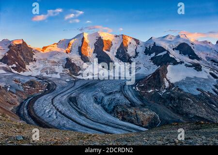 The summits of Piz Cambrena, Piz Palü and Bella Vista and the upper part of Pers Glacier, seen from Munt Pers near Diavolezza at sunset. Stock Photo