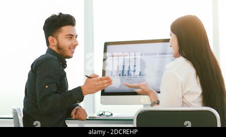 rear view. two employees discuss work issues sitting at the offi Stock Photo