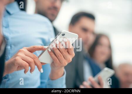 close up. happy business people reading SMS on their smartphones. Stock Photo