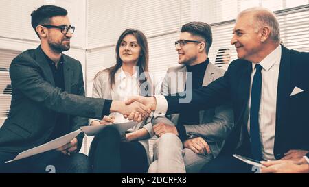 business partners shaking hands after discussing a new contract. Stock Photo