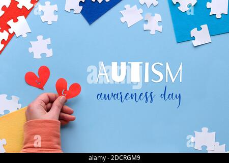 Puzzle pieces, text Autism Awareness Day on blue background. Flat lay, top view with jigsaw puzzle pieces Stock Photo