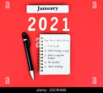 List of New Year's resolution on notepad with red background. Happy New Year 2021 concept Stock Photo