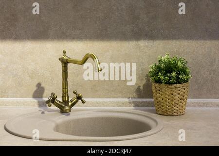 round porcelain tile kitchen sink on the kitchen countertop and retro brass faucet Stock Photo