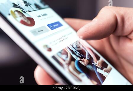 Profile page on social media or online portal. Man reading feed, status update or post with mobile phone. Follow, like or send friend request. Stock Photo