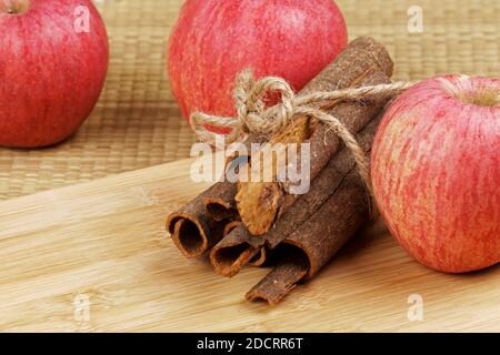 Delicious cinnamon bark and red apples on a wooden background Stock Photo
