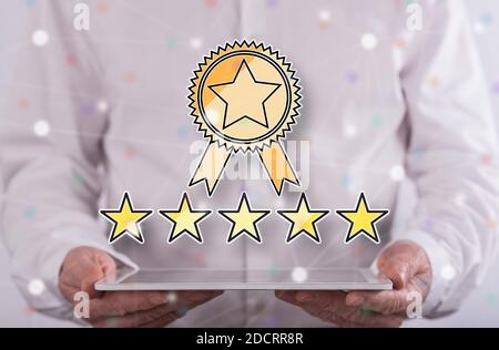 Quality concept above a tablet held by a man in background Stock Photo