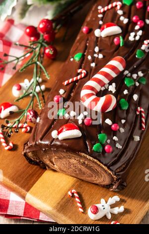 Chocolate yule log christmas cake on wooden table Stock Photo