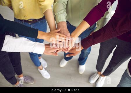 Close-up of business people or friends putting hands together as symbol of cooperation, teamwotk, unity Stock Photo