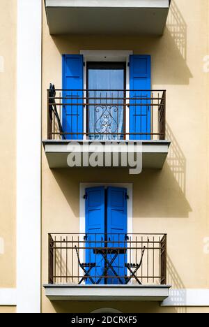 Two balconies with blue doors at the facade of a house in the old part of town. Stock Photo