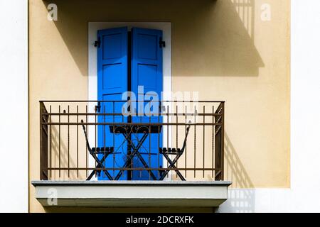 A balcony with blue doors at the facade of a house in the old part of town. Stock Photo