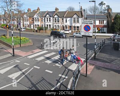 A family cross the road using a newly remodelled zebra crossing, Addison Rd, London. Part of Waltham Forest's Mini Holland scheme for safer streets. Stock Photo