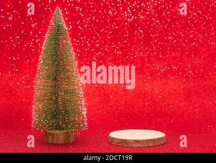 A christmas tree and product stand, round wooden piece on a red blur background Stock Photo