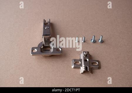 One furniture and kitchen cabinet hinges lays on cartboard Stock Photo