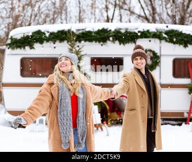 Romantic couple camping at winter with campervan, enjoying snow and cold weather Stock Photo