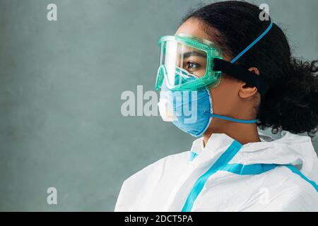 Side view of medical worker wearing suit, respirator and glasses Stock Photo