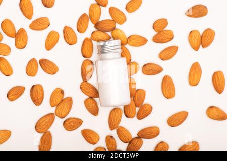 top view of bottle with refreshing lotion near almonds on white surface Stock Photo