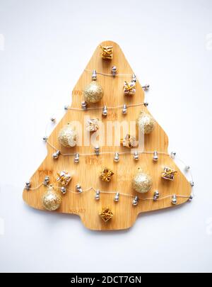 beautiful wooden christmas tree with garland and ornaments on white background. Stock Photo