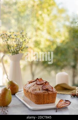 muffin cake with pears, nuts on a window background. Light background Stock Photo