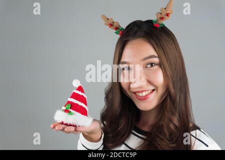 https://l450v.alamy.com/450v/2dctc9p/a-happy-woman-holds-a-christmas-decoration-grey-background-high-quality-photo-2dctc9p.jpg