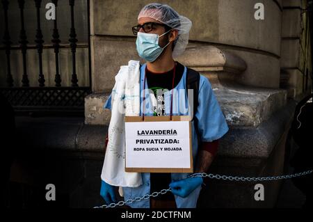 Madrid, Spain. 23rd Nov, 2020. Healthcare worker protesting with a placard reading 'privatized laundry: dirty and wet clothes'. Representatives of all hospital services have chained themselves around the health department to protest demanding better working conditions and against the mistreatment of their sector during the coronavirus (COVID-19) pandemic. Credit: Marcos del Mazo/Alamy Live News Stock Photo