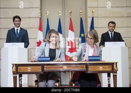French President Emmanuel Macron (R) and Canadian Prime Minister Justin Trudeau (L) look as French Culture Minister Francoise Nyssen (2nd R) and Canadian Heritage Minister Melanie Joly (2nd L) sign an agreement at the Elysee Palace in Paris on April 16, 2018. Trudeau is on a two-day official visit to France. Photo by Eliot Blondet/ABACAPRESS.COM Stock Photo
